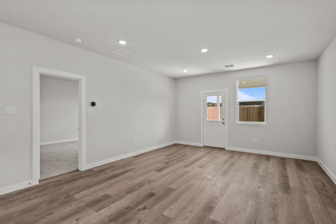 A room with a wood floor and white walls.