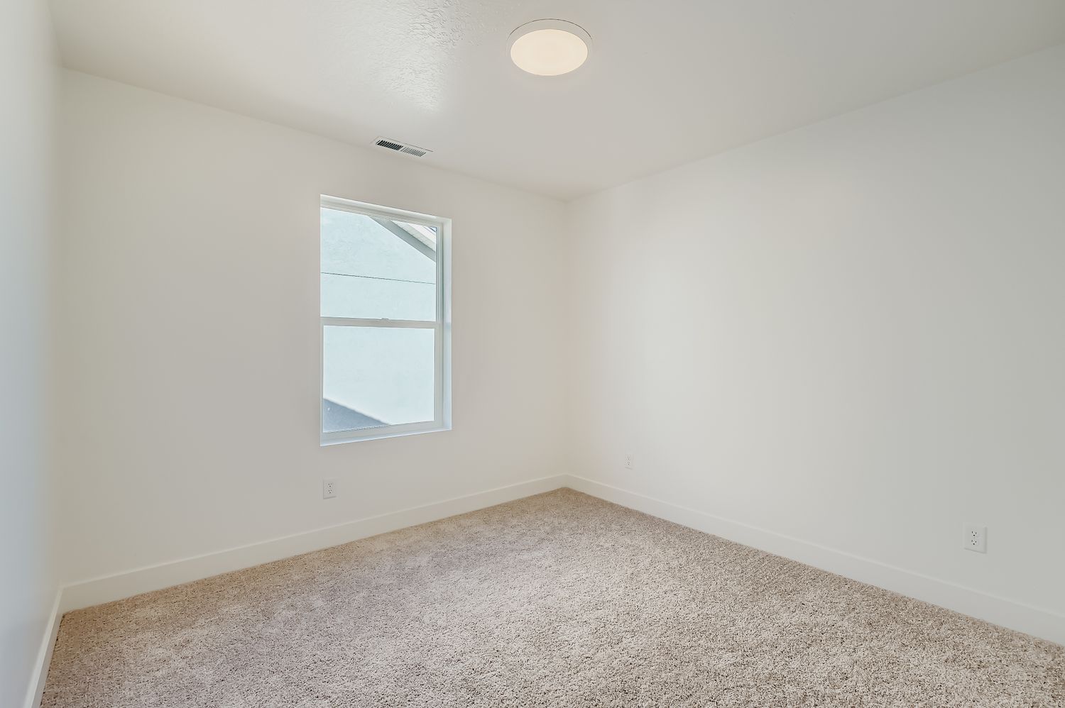 A room with a window and carpet.