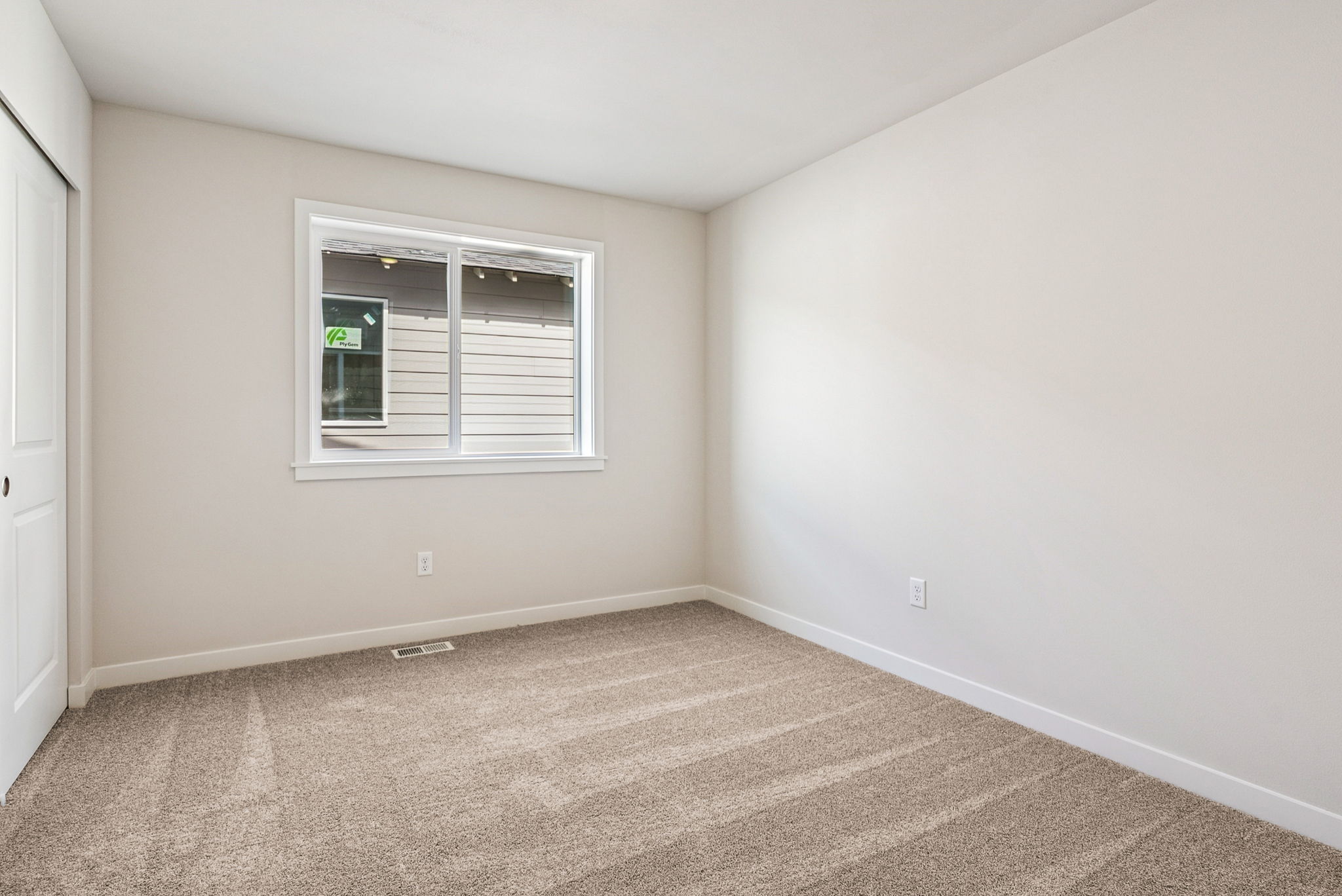 A room with a window and carpet.