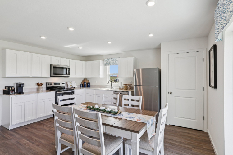A kitchen with white cabinets.