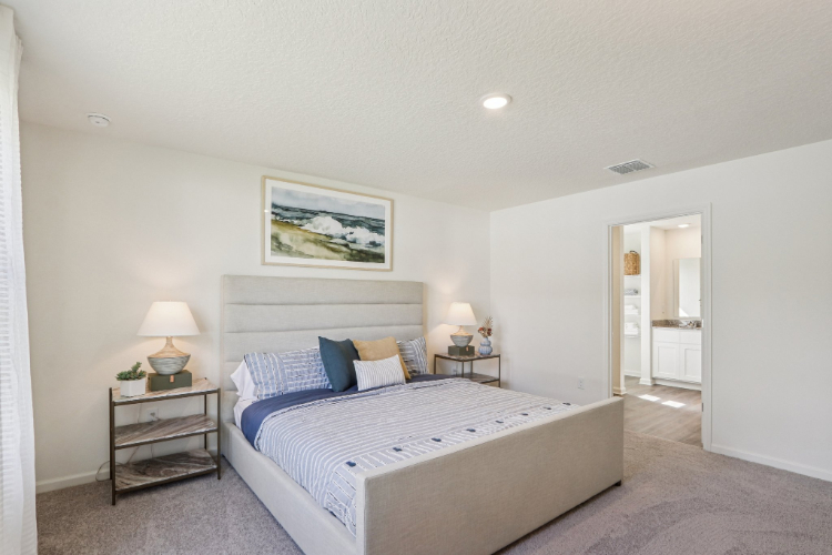 A bedroom with a bed and lamps.