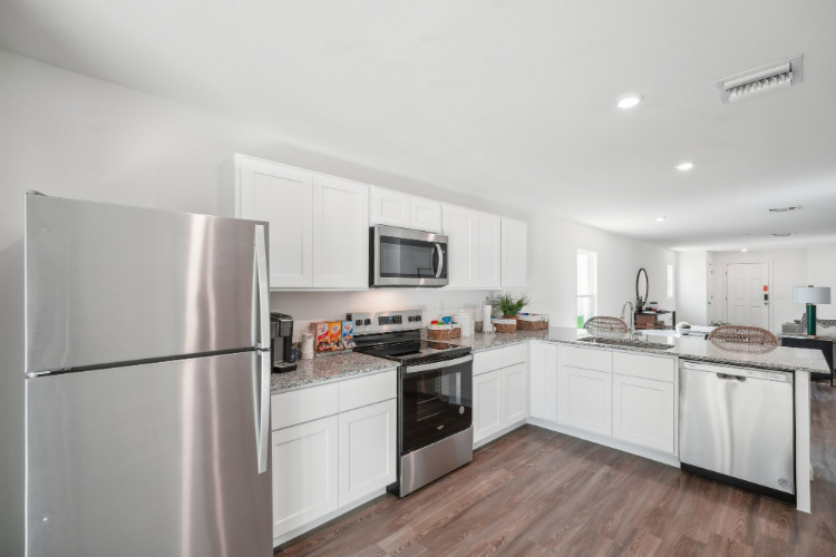 A kitchen with white cabinets.