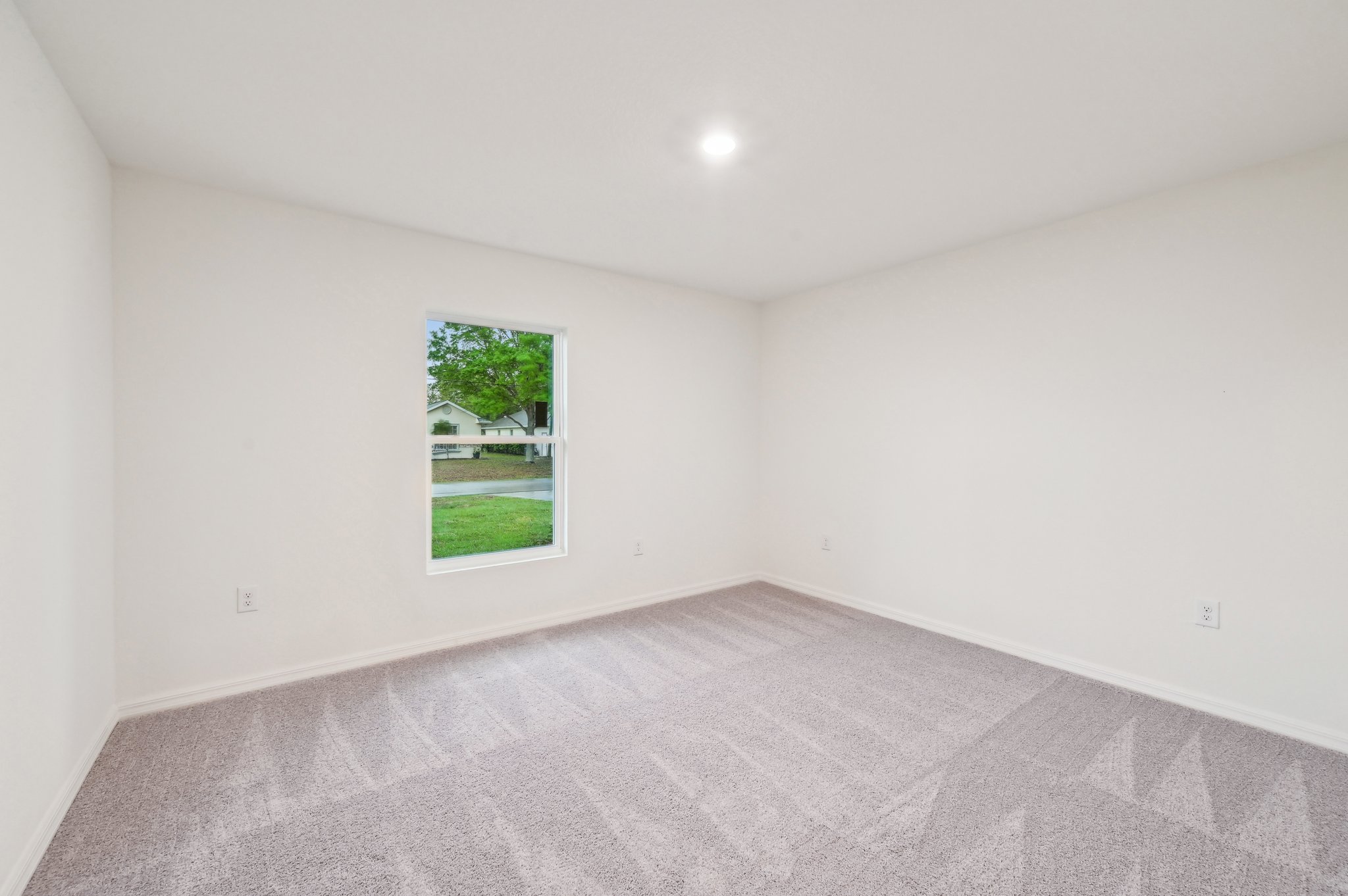 A room with a carpet and a window.