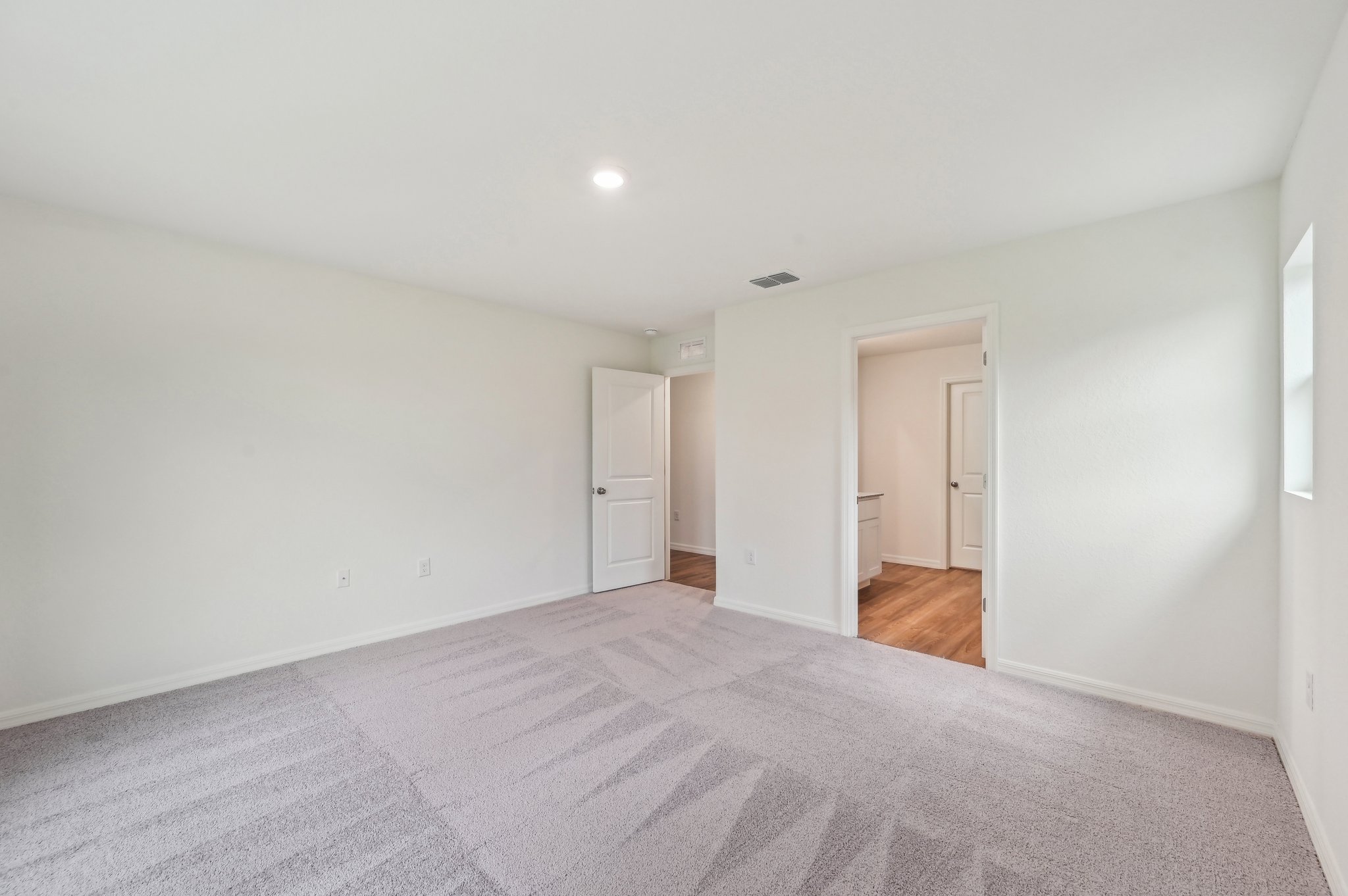 A room with a carpet and a door.