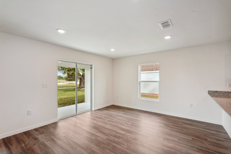 A room with a wood floor and a wood floor with a window.