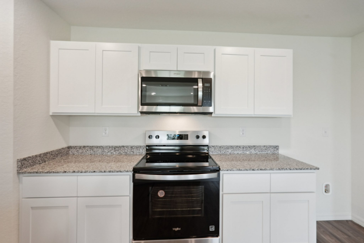 A kitchen with white cabinets.