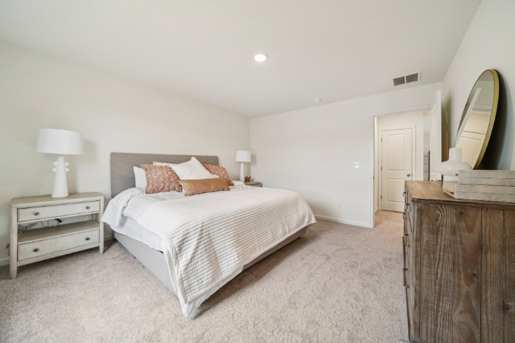 A bedroom with a bed and lamps.