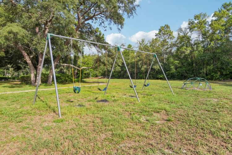A playground with trees and grass.