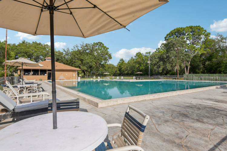 A pool with chairs and umbrellas.