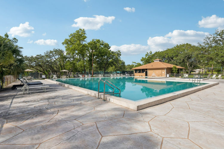 A swimming pool with trees and a building in the background.