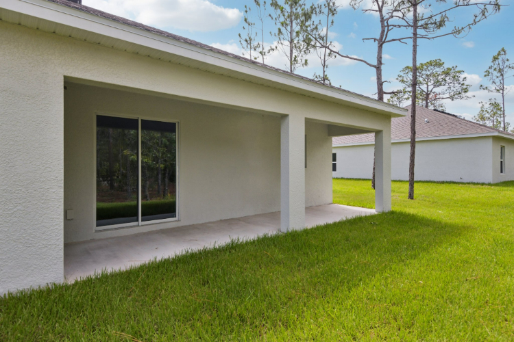 A white house with a grass yard.
