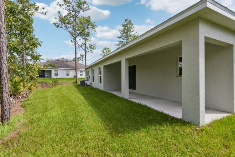 A white house with a green lawn.