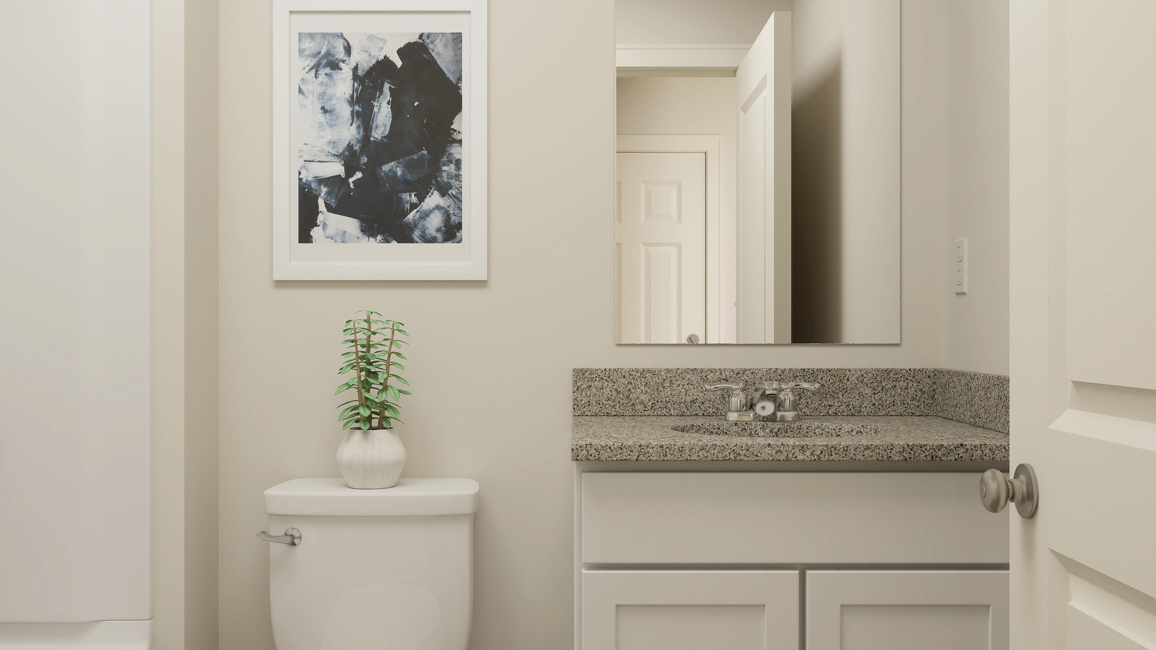 A bathroom with a plant on the counter.