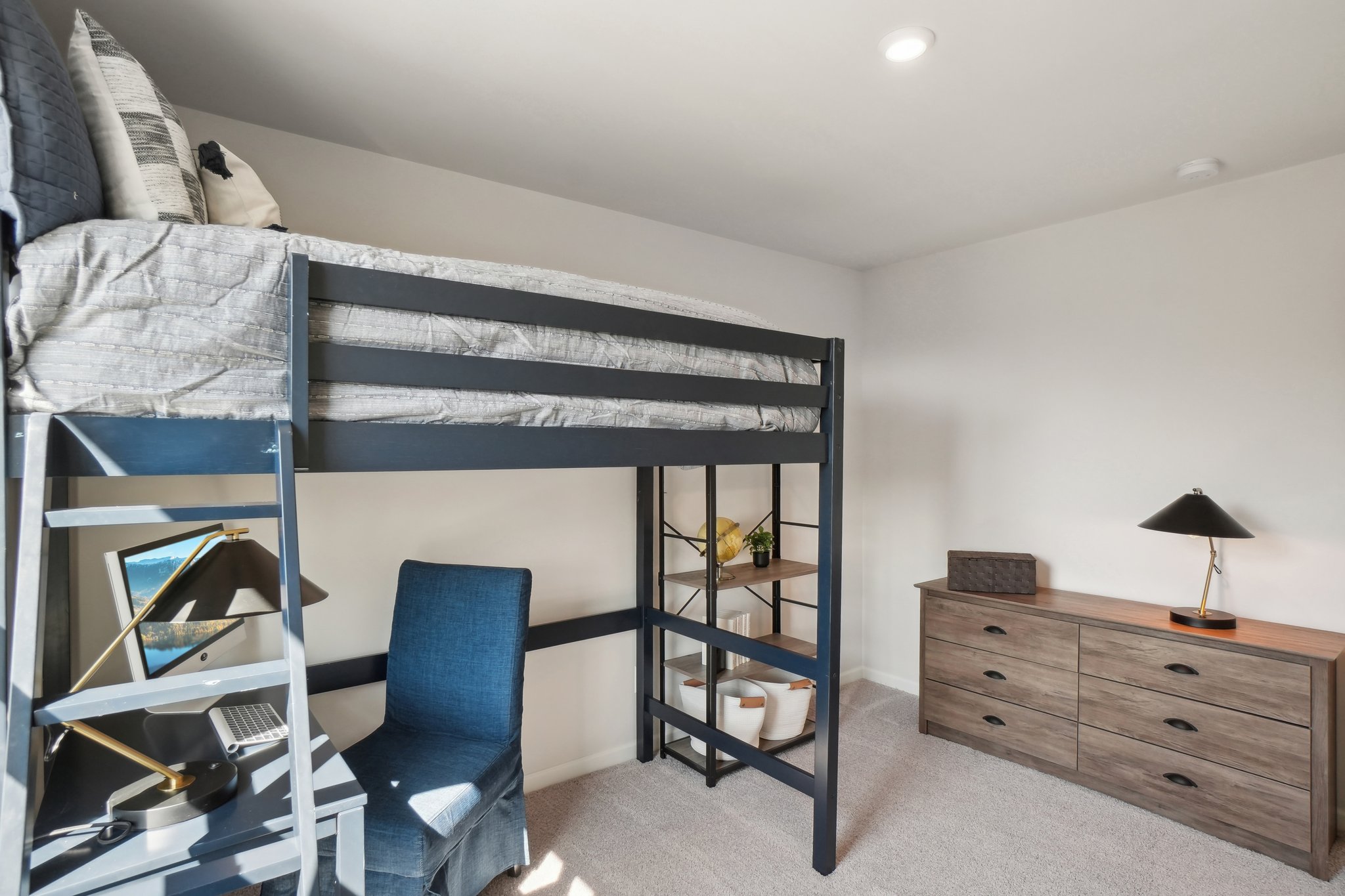A bedroom with a bunk bed and a chair.
