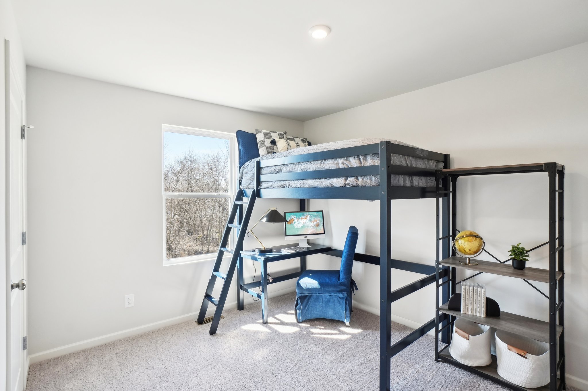 A room with a bunk bed and a chair.