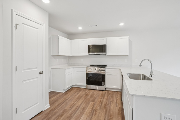 A kitchen with white cabinets.